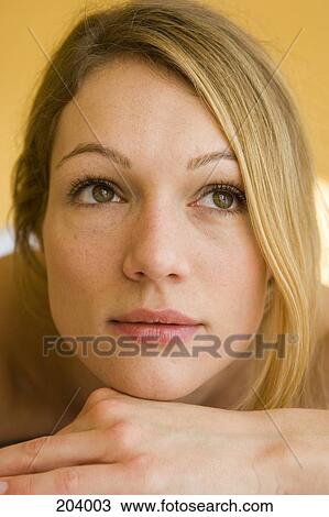 Young woman resting chin on hand View Large Photo Image Stock Image - Young woman resting chin on hand. Fotosearch