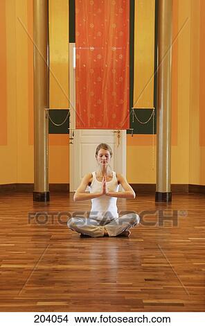 Young woman sitting on floor meditating View Large Photo Image Picture - Young woman sitting on floor meditating. Fotosearch