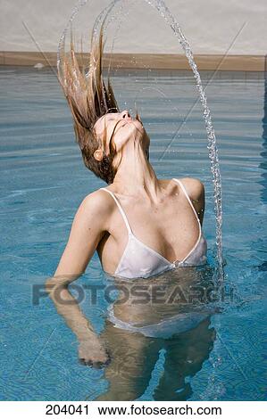 Young woman tossing hair back in swimming pool View Large Photo Image Stock Image - Young woman tossing hair back in swimming pool. Fotosearch