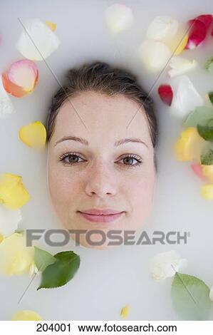 Young woman's face above bath water and surrounded by rose petals View Large Photo Image Stock Image - Young woman's face above bath water and surrounded by rose petals. Fotosearch