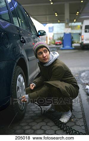 Man checking air pressure of car tire View Large Photo Image Stock Photo - Man checking air pressure of car tire. Fotosearch