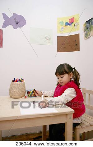A young girl coloring at a table View Large Photo Image Picture - A young girl coloring at a table. Fotosearch