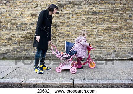 Stock Image - Mother and daughter on sidewalk. Fotosearch