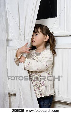 Stock Photography - Young girl holding a curtain. Fotosearch