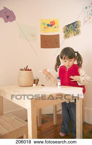 Stock Photo - Young girl using art and craft materials. Fotosearch