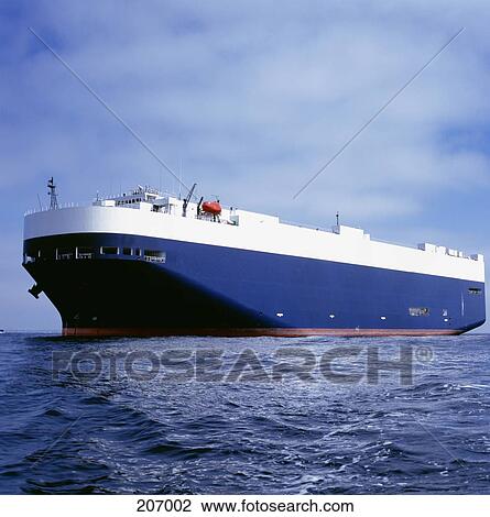 Stock Image - Cargo ship sailing at sea. Fotosearch