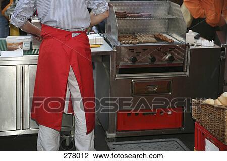 Market vendor cooking sausages View Large Photo Image Stock Image - Market vendor cooking sausages. Fotosearch