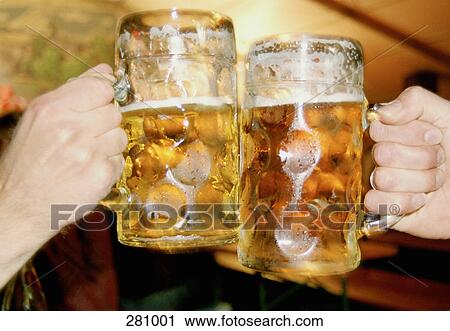 Stock Image - Two men toasting with beer steins. Fotosearch