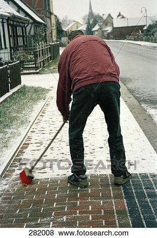 Man sweeping snow on sidewalk View Large Photo Image Stock Photo - Man sweeping snow on sidewalk. Fotosearch