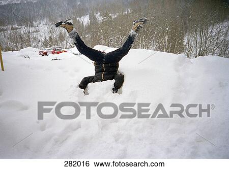 Man with head buried in pile of snow View Large Photo Image Stock Photograph - Man with head buried in pile of snow. Fotosearch