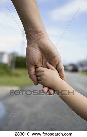 Stock Image - Father holding child’s hand. Fotosearch