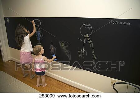 Two young girls drawing on blackboard View Large Photo Image Stock Photo - Two young girls drawing on blackboard. Fotosearch