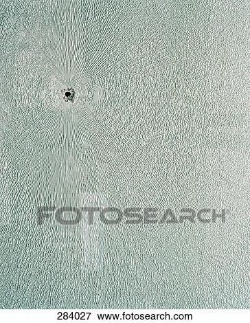 Bullet hole in textured surface View Large Photo Image Stock Photo - Bullet hole in textured surface. Fotosearch