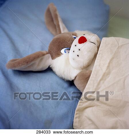 Stock Image - Toy rabbit in bed. Fotosearch