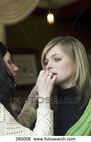 Makeup artist applying lipstick to a model View Large Photo Image Stock Photograph - Makeup artist applying lipstick to a model. Fotosearch