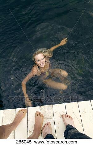 Young woman swimming and friends standing on pier View Large Photo Image Stock Photography - Young woman swimming and friends standing on pier. Fotosearch