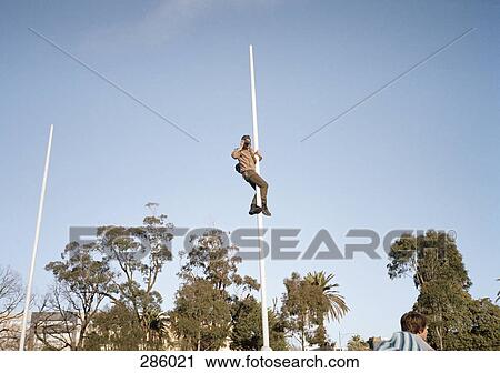 Man taking photograph whilst climbing goal post View Large Photo Image Stock Image - Man taking photograph whilst climbing goal post. Fotosearch
