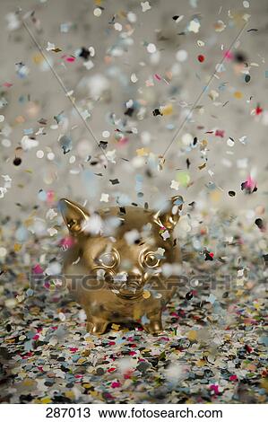 Gold piggy bank amongst floating confetti View Large Photo Image Stock Image - Gold piggy bank amongst floating confetti. Fotosearch