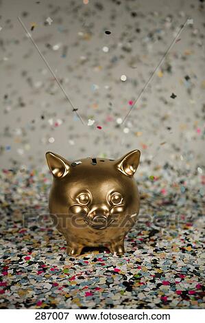 Gold piggy bank amongst floating confetti View Large Photo Image Stock Photo - Gold piggy bank amongst floating confetti. Fotosearch
