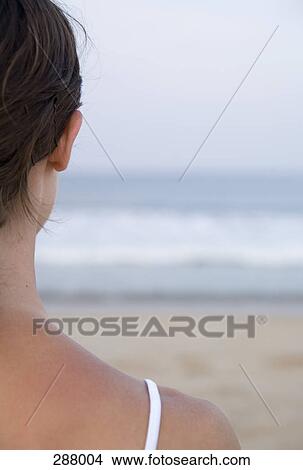 Picture - Woman on beach looking out to sea. Fotosearch