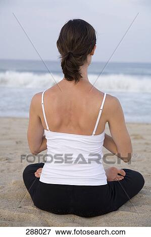 Woman sitting on beach in lotus position View Large Photo Image Stock Photo - Woman sitting on beach in lotus position. Fotosearch