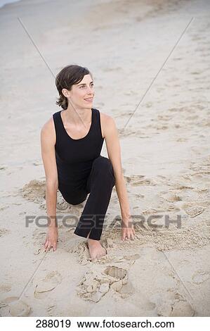 Woman stretching on beach View Large Photo Image Stock Photo - Woman stretching on beach. Fotosearch
