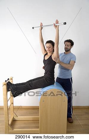 Instructor adjusting posture of woman exercising on pommel horse View Large Photo Image Picture - Instructor adjusting posture of woman exercising on pommel horse. Fotosearch