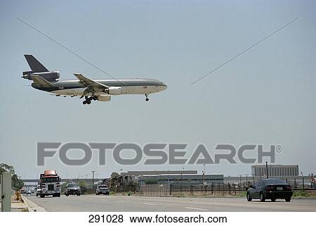 Airplane flying above multiple lane highway View Large Photo Image Stock Photo - Airplane flying above multiple lane highway. Fotosearch