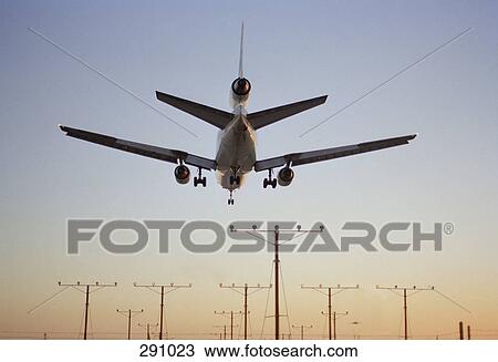 Airplane landing at dusk View Large Photo Image Stock Image - Airplane landing at dusk. Fotosearch