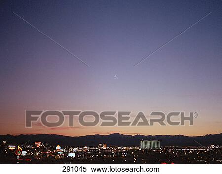Stock Photography - Cityscape at night and mountains in distance. Fotosearch