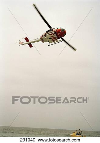 Fire rescue helicopter flying above boat at sea View Large Photo Image Stock Image - Fire rescue helicopter flying above boat at sea. Fotosearch