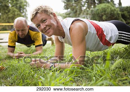 A man and woman stretching in a park View Large Photo Image Stock Image - A man and woman stretching in a park. Fotosearch