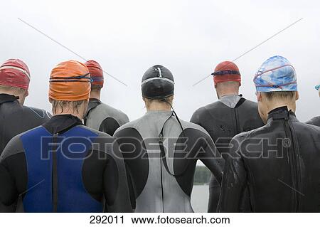 Group of triathletes standing by lake View Large Photo Image Stock Image - Group of triathletes standing by lake. Fotosearch