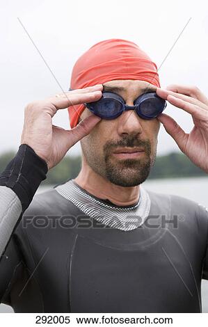 Male triathlete adjusting swimming goggles View Large Photo Image Stock Photography - Male triathlete adjusting swimming goggles. Fotosearch
