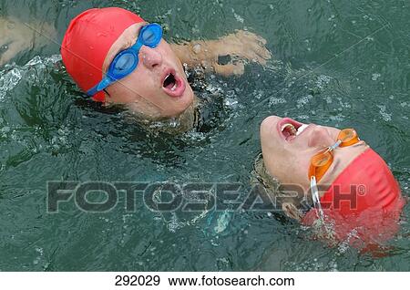 Two exhausted swimmers in a lake with their heads above water View Large Photo Image Stock Photo - Two exhausted swimmers in a lake with their heads above water. Fotosearch