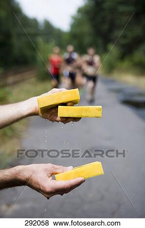 Stock Photo - Wet sponges for athletes running in triathlon. Fotosearch