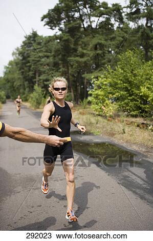 Woman running and reaching for wet sponge in sports race View Large Photo Image Stock Image - Woman running and reaching for wet sponge in sports race. Fotosearch