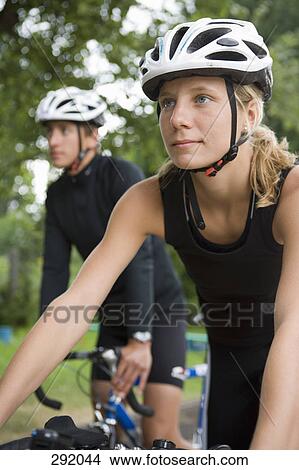 Young couple cycling through park together View Large Photo Image Picture - Young couple cycling through park together. Fotosearch