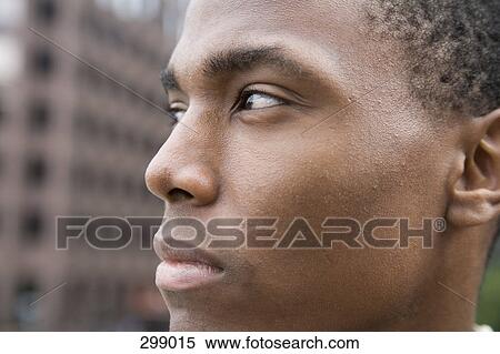 Close-up of young man looking away View Large Photo Image Stock Photography - Close-up of young man looking away. Fotosearch