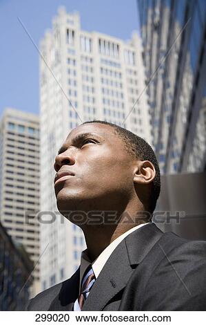Young businessman in financial district looking up View Large Photo Image Stock Image - Young businessman in financial district looking up. Fotosearch