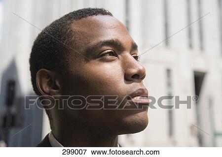 Young businessman in financial district looking up View Large Photo Image Stock Photo - Young businessman in financial district looking up. Fotosearch