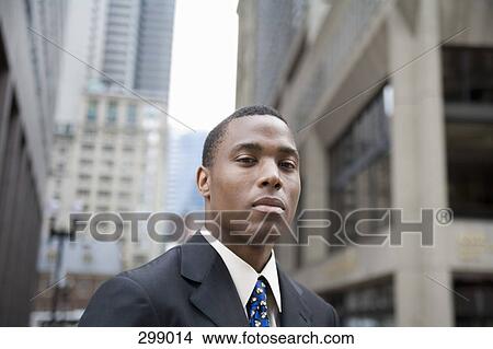 Young businessman standing in financial district View Large Photo Image Picture - Young businessman standing in financial district. Fotosearch
