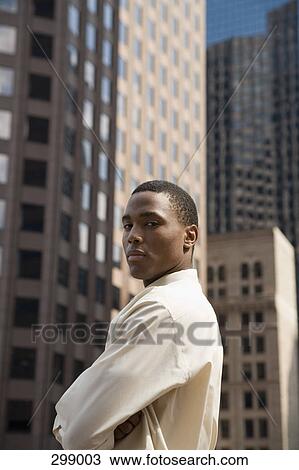 Stock Image - Young businessman standing in financial district. Fotosearch