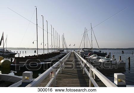 Stock Photograph - Jetty with sailboats moored alongside. Fotosearch