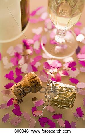 Stock Photograph - Part of table with champagne, cork and decoration. Fotosearch