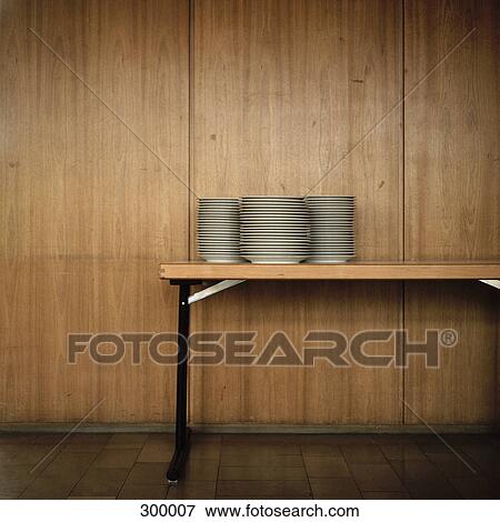 Stack of plates on table, in front of wood grain background View Large Photo Image Stock Photo - Stack of plates on table, in front of wood grain background. Fotosearch