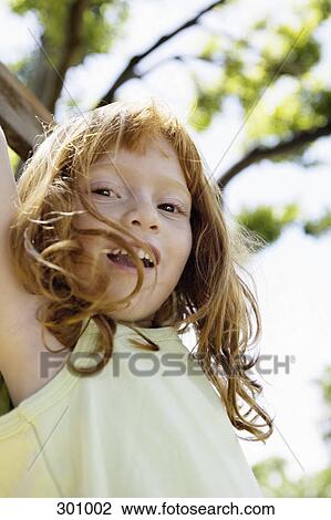 Close-up of girl swinging from tree View Large Photo Image Stock Image - Close-up of girl swinging from tree. Fotosearch