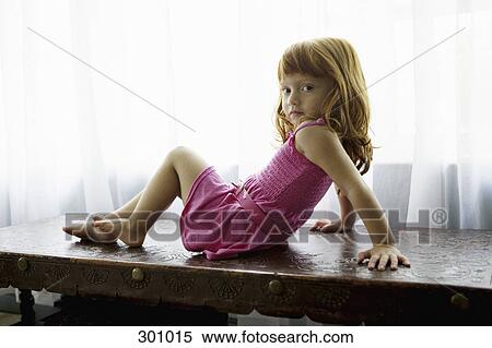 Girl sitting on desk posing View Large Photo Image Stock Photography - Girl sitting on desk posing. Fotosearch