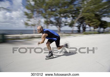 Stock Image - Man inline skating, blurred motion. Fotosearch