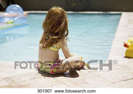 Rear view of girl sitting on pool side View Large Photo Image Stock Photo - Rear view of girl sitting on pool side. Fotosearch